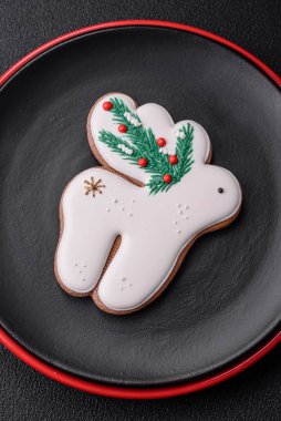 Seramik tabaklar, zencefilli çörekler ve koyu beton arkaplanda yeni yıl süslemelerinin diğer unsurlarından oluşan güzel bir Noel kompozisyonu