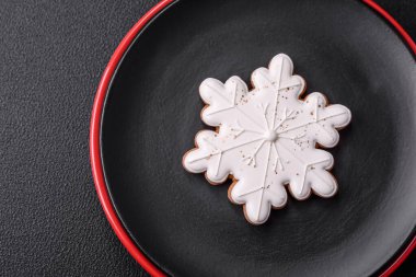 Seramik tabaklar, zencefilli çörekler ve koyu beton arkaplanda yeni yıl süslemelerinin diğer unsurlarından oluşan güzel bir Noel kompozisyonu