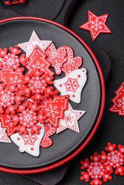 Seramik tabaklar, zencefilli çörekler ve koyu beton arkaplanda yeni yıl süslemelerinin diğer unsurlarından oluşan güzel bir Noel kompozisyonu