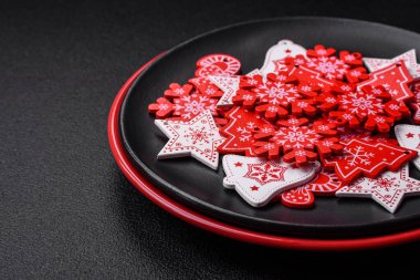 Seramik tabaklar, zencefilli çörekler ve koyu beton arkaplanda yeni yıl süslemelerinin diğer unsurlarından oluşan güzel bir Noel kompozisyonu