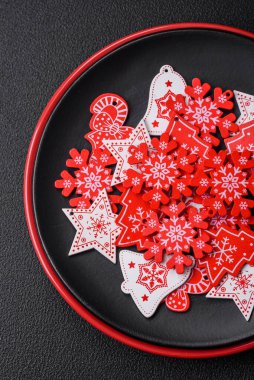 Seramik tabaklar, zencefilli çörekler ve koyu beton arkaplanda yeni yıl süslemelerinin diğer unsurlarından oluşan güzel bir Noel kompozisyonu