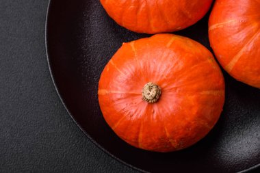 Koyu beton arka planda turuncu renkli güzel yuvarlak balkabakları. Cadılar Bayramı kutlamasına hazırlanıyorum.