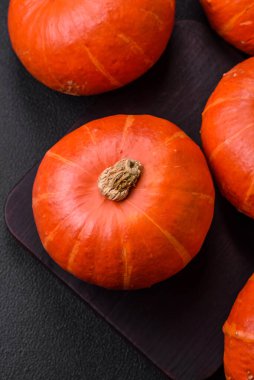 Koyu beton arka planda turuncu renkli güzel yuvarlak balkabakları. Cadılar Bayramı kutlamasına hazırlanıyorum.