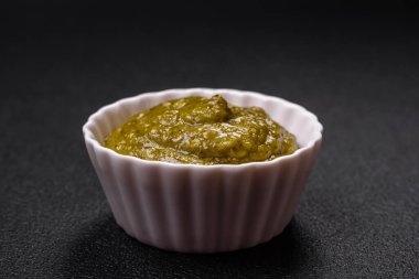 Tuz, baharat ve otlu, koyu beton arka planda pesto soslu lezzetli taze makarna.