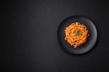  Pesto soslu lezzetli taze makarna, tuz, baharatlar ve çimento kaplı seramik bir tabakta otlar.