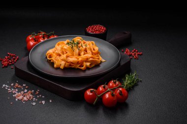 Pesto soslu lezzetli taze makarna, tuz, baharatlar ve çimento kaplı seramik bir tabakta otlar.
