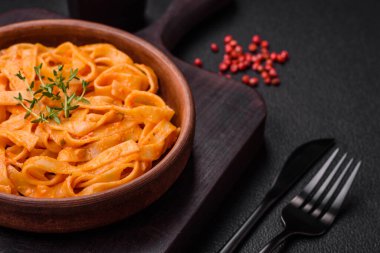  Pesto soslu lezzetli taze makarna, tuz, baharatlar ve çimento kaplı seramik bir tabakta otlar.