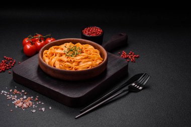  Pesto soslu lezzetli taze makarna, tuz, baharatlar ve çimento kaplı seramik bir tabakta otlar.