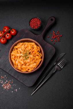  Pesto soslu lezzetli taze makarna, tuz, baharatlar ve çimento kaplı seramik bir tabakta otlar.