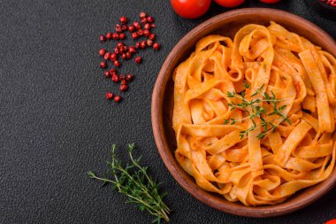  Pesto soslu lezzetli taze makarna, tuz, baharatlar ve çimento kaplı seramik bir tabakta otlar.