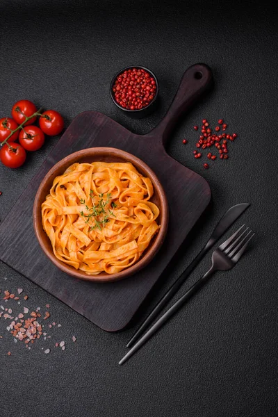  Pesto soslu lezzetli taze makarna, tuz, baharatlar ve çimento kaplı seramik bir tabakta otlar.