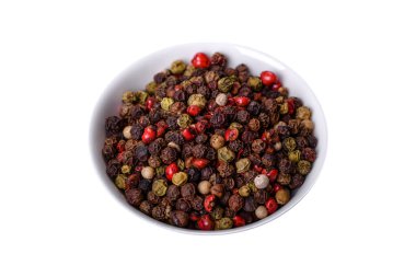 Koyu beton arkaplanda beyaz bir tabakta üç farklı renkte bezelye aromalı biber baharatı.