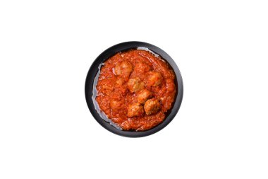 Siyah tavada servis edilen baharatlı domates soslu kıymadan yapılan lezzetli köfteler.
