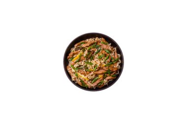 Lezzetli Asya yemekleri pilav eriştesi, tavuk, kuşkonmaz, biber, susam tohumu ve soya sosu ile koyu beton arka planda.