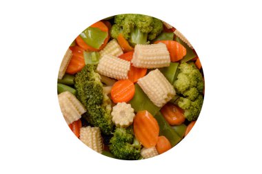 Sebze karışımı: havuç, küçük mısır başları, siyah seramik tabakta pişirilmiş kuşkonmaz fasulyeleri.