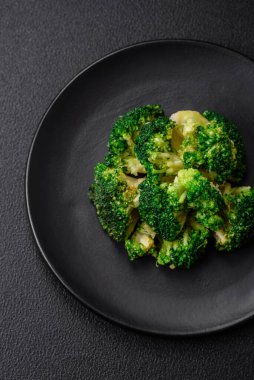 Lezzetli taze brokoli, dokulu beton arka planda seramik bir tabakta buğulanmış.