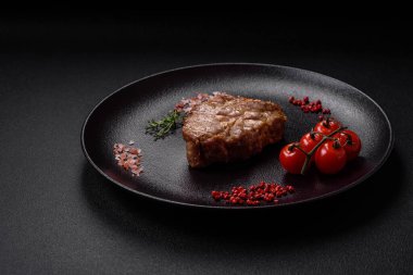 Izgarada pişirilmiş lezzetli, sulu domuz eti ya da biftek. Tuzlu ve baharatlı beton bir arka planda.