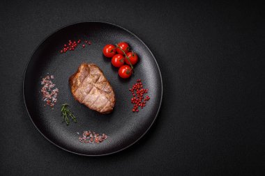 Izgarada pişirilmiş lezzetli, sulu domuz eti ya da biftek. Tuzlu ve baharatlı beton bir arka planda.