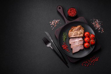 Izgarada pişirilmiş lezzetli, sulu domuz eti ya da biftek. Tuzlu ve baharatlı beton bir arka planda.