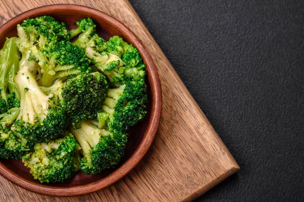 Delicious fresh green broccoli steamed in a ceramic plate on a textured concrete background