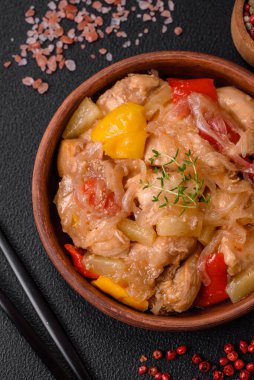 Lezzetli bir yemek tavuk dilimleri, tatlı biber ve soğan ile tuzlu ve baharatlı koyu beton arka planda.