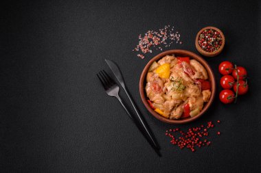 Lezzetli bir yemek tavuk dilimleri, tatlı biber ve soğan ile tuzlu ve baharatlı koyu beton arka planda.