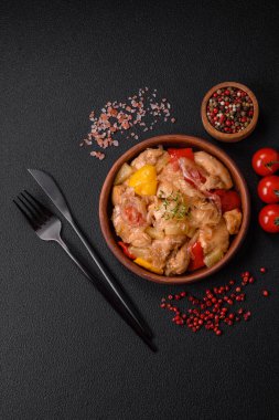 Lezzetli bir yemek tavuk dilimleri, tatlı biber ve soğan ile tuzlu ve baharatlı koyu beton arka planda.