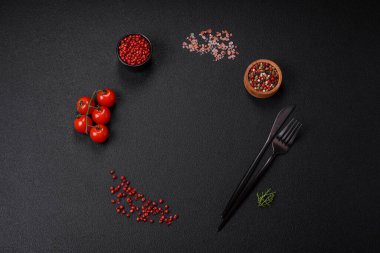 Koyu beton zeminde domates, tuz, baharat ve otlar pişirmek için gerekli malzemeler.