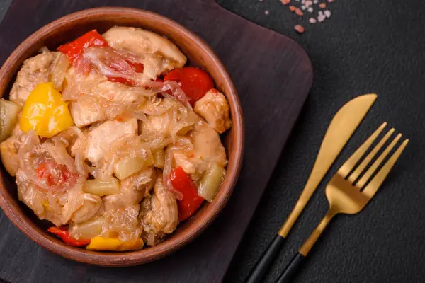 Lezzetli bir yemek tavuk dilimleri, tatlı biber ve soğan ile tuzlu ve baharatlı koyu beton arka planda.