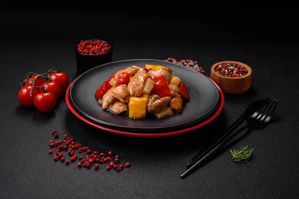 Lezzetli bir yemek tavuk dilimleri, tatlı biber ve soğan ile tuzlu ve baharatlı koyu beton arka planda.