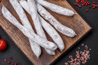 Lezzetli İspanyol füme sosis füeti. Koyu beton arka planda tuz ve baharatlarla birlikte.