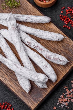 Lezzetli İspanyol füme sosis füeti. Koyu beton arka planda tuz ve baharatlarla birlikte.