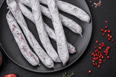 Lezzetli İspanyol füme sosis füeti. Koyu beton arka planda tuz ve baharatlarla birlikte.