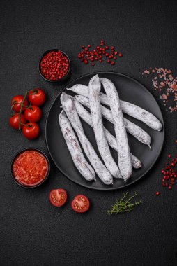 Lezzetli İspanyol füme sosis füeti. Koyu beton arka planda tuz ve baharatlarla birlikte.