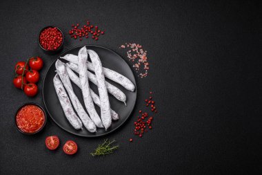 Lezzetli İspanyol füme sosis füeti. Koyu beton arka planda tuz ve baharatlarla birlikte.