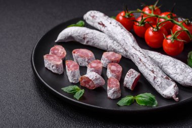 Lezzetli İspanyol füme sosis füeti. Koyu beton arka planda tuz ve baharatlarla birlikte.