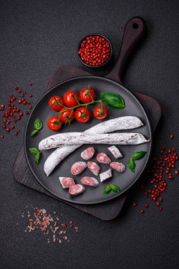 Lezzetli İspanyol füme sosis füeti. Koyu beton arka planda tuz ve baharatlarla birlikte.