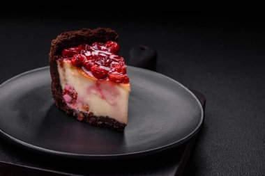 Lezzetli, peynirli, kiraz meyveli ve koyu betondan arkaplanda reçelli cheesecake keki.