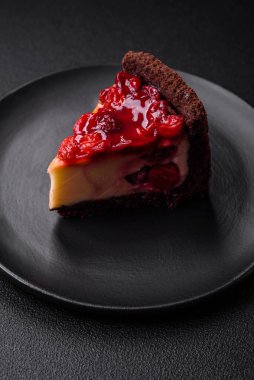 Lezzetli, peynirli, kiraz meyveli ve koyu betondan arkaplanda reçelli cheesecake keki.