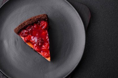 Lezzetli, peynirli, kiraz meyveli ve koyu betondan arkaplanda reçelli cheesecake keki.