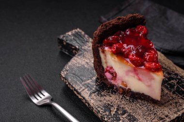 Lezzetli, peynirli, kiraz meyveli ve koyu betondan arkaplanda reçelli cheesecake keki.