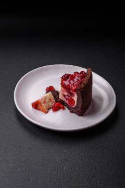 Lezzetli, peynirli, kiraz meyveli ve koyu betondan arkaplanda reçelli cheesecake keki.