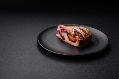 Lezzetli ev yapımı aromalı turta. Koyu beton arka planda olgun erikli.