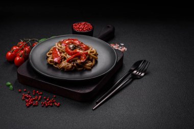 Sebzeli, mantarlı, tuzlu ve baharatlı lezzetli Asya udonu tabağı koyu beton arka planda.