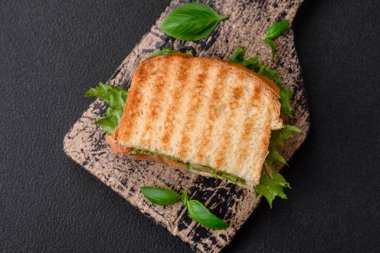 Tost, somon, avokado, domates, tuz, baharat ve çimento kaplı lezzetli çıtır sandviçler.