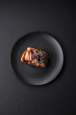 Lezzetli ızgara somon filetosu. Tuz, baharat, şifalı otlar ve koyu beton arka planda sos.