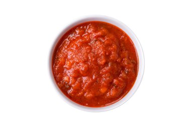 Lezzetli kırmızı Napoletana sosu soğan, tuz, baharat ve otlarla birlikte koyu beton bir arka planda beyaz bir kasede.