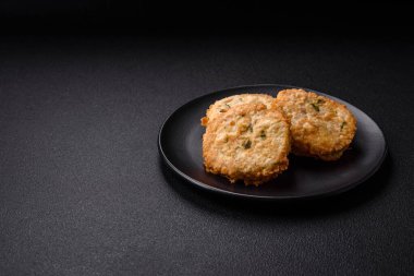 Lezzetli kızarmış balık pirzolası ya da koyu beton arka planda tuzlu, baharatlı ve otlu köfte.