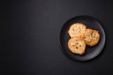 Lezzetli kızarmış balık pirzolası ya da koyu beton arka planda tuzlu, baharatlı ve otlu köfte.