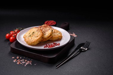 Lezzetli kızarmış balık pirzolası ya da koyu beton arka planda tuzlu, baharatlı ve otlu köfte.